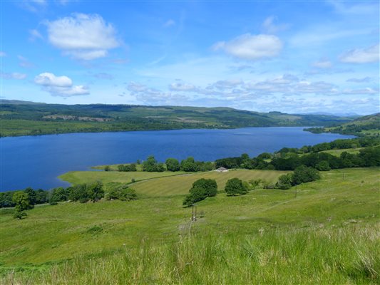 a green hillside and a long loch in argyll