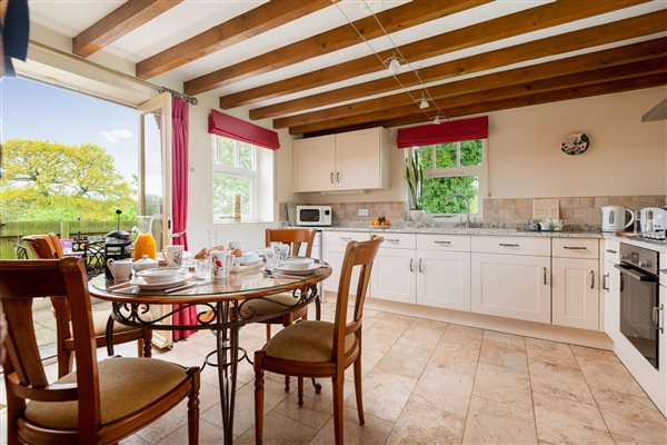 Well equipped kitchen with dining table and doors onto the garden