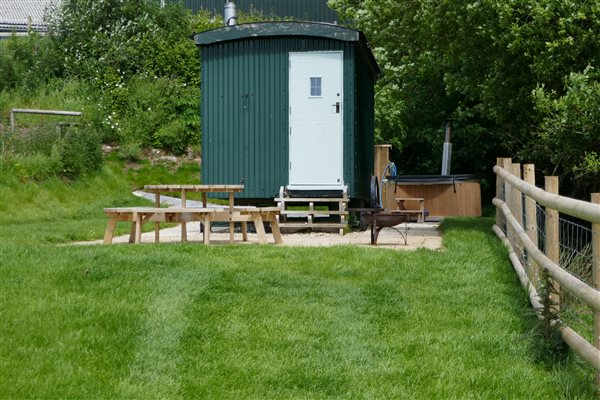Shepherds Hut Exterior - Patio area with Picnic bench, BBQ and Hot tub