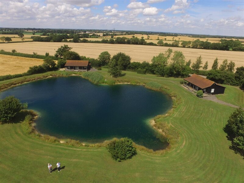 Swallows and Kingfisher Lodges at Rumburgh Farm in Suffolk, offering lakeside self-catering cabins with verandahs overlooking stocked trout and carp lakes. Ideal for fishing, birdwatching, and relaxing in the peaceful countryside near Halesworth.