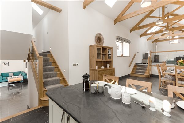 Breakfast bar leading to dinning room and lounge with exposed oak beams