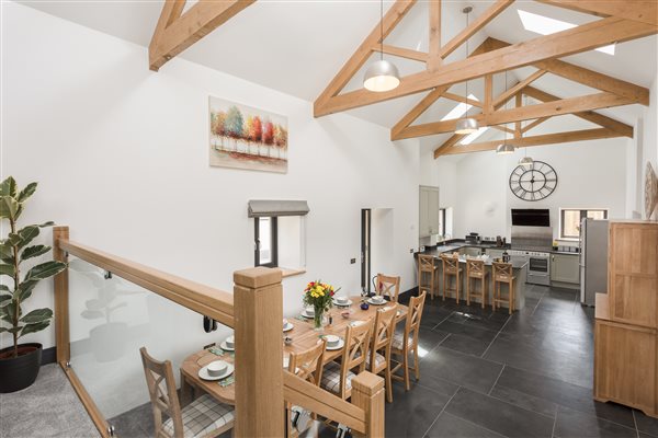 exposed oak beams, stairs leading to dining area and onto open plan kitchen with slate floors