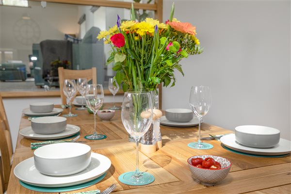 Oak dinning table ready for dinner with crockery and glasses