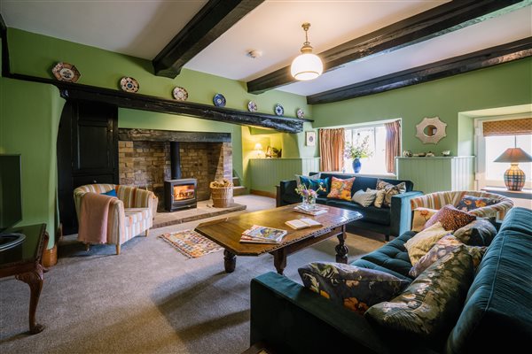 A spacious yet inviting living room with wood burner