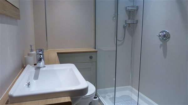 shower room in holiday cottage with toilet, sink and walk in shower
