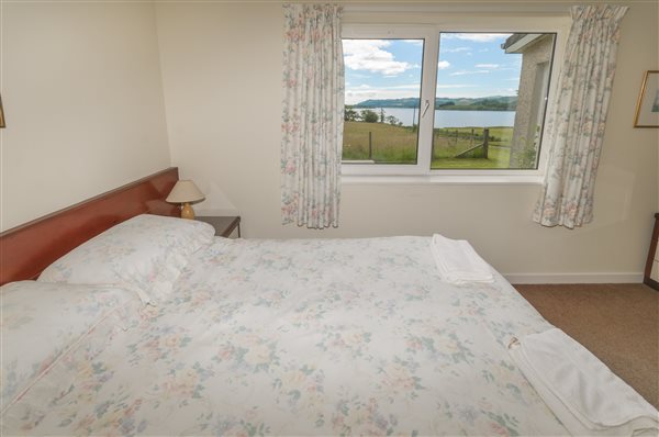 bedroom with a view of a scottish loch