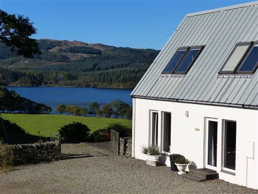 building, field, trees loch and hill