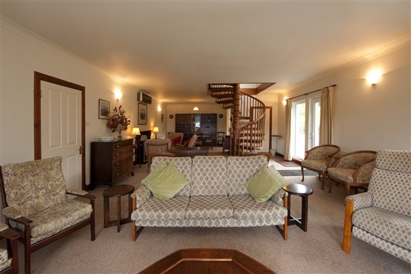 Large lounge with seating and a spiral staircase