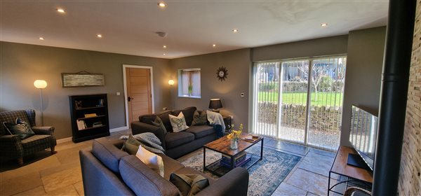 living area with tv, bookcase, wingback armchair and 2 sofas