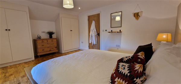 master bedroom, two built in wardrobes in white with a chest of drawers between them. mirror on the wall to the right