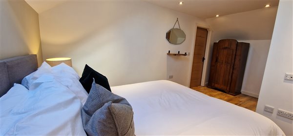 king size bedroom showing the vintage wardrobe in the corner by the door