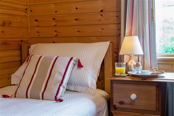 single bed with bedside lamp and breakfast plate 