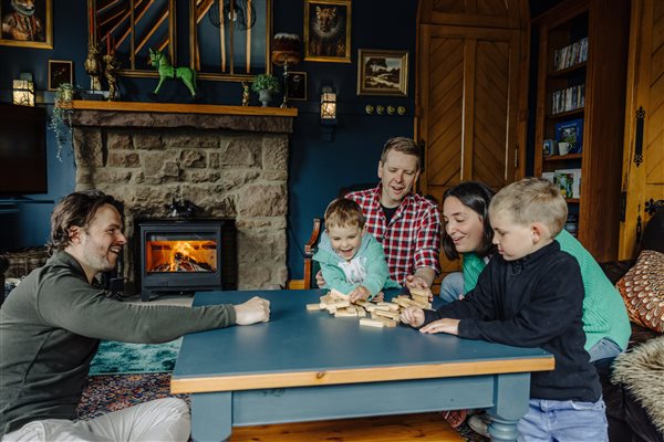 A family having fun in the lounge in front of the log burning stove