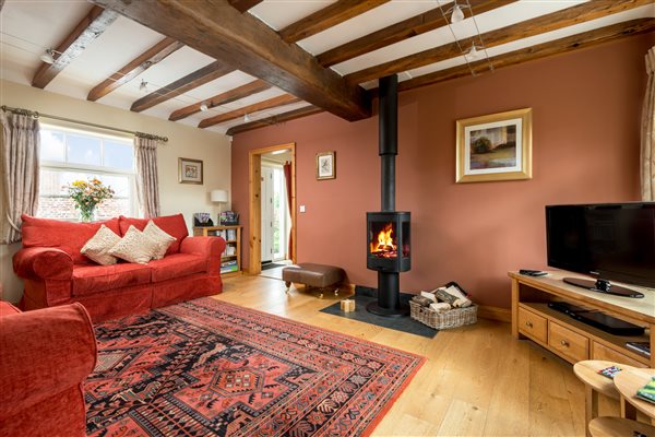 living room with beams and woodburner