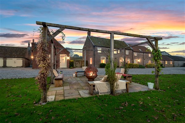 Fireball lit at dusk in the garden in front of the holiday cottages