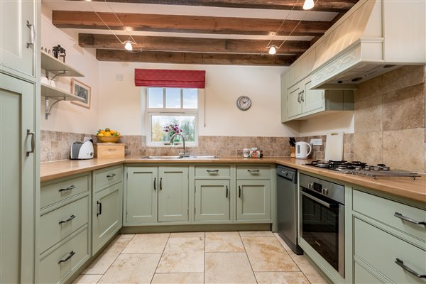 Green kitchen with beamed ceiling