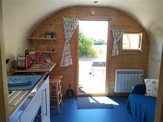 Kitchenette, shelving, worktop, radiator, sofa, accommodation, glamping pod, glamping, Maldon, Essex, UK