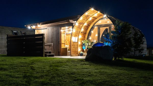 Luxury glamping pod illuminated at night, featuring a beautifully lit curved entrance, warm outdoor lighting and a peaceful countryside setting. Luxury glamping pod illuminated at night, featuring a beautifully lit curved entrance, warm outdoor lighting and a peaceful countryside setting.