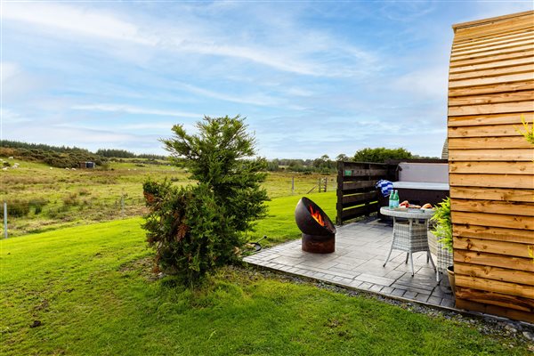 Private outdoor hot tub at a luxury glamping pod, with a secluded patio, garden seating and beautiful countryside views. Private outdoor hot tub at a luxury glamping pod, with a secluded patio, garden seating and beautiful countryside views.