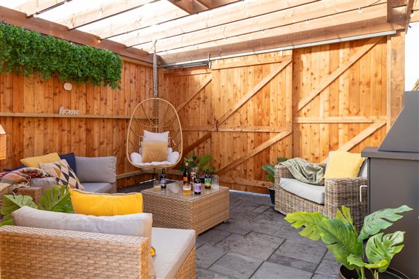 Private sheltered outdoor seating area at Galloway Retreats, featuring comfortable rattan sofas, hanging egg chair, cosy cushions and wooden privacy fencing. Private sheltered outdoor seating area at Galloway Retreats, featuring comfortable rattan sofas, hanging egg chair, cosy cushions and wooden privacy fencing.