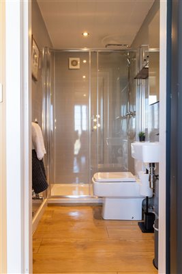 Modern ensuite bathroom at Galloway Retreats luxury cabin, featuring a glass-enclosed walk-in shower, contemporary toilet, washbasin and stylish finishes. Modern ensuite bathroom at Galloway Retreats luxury cabin, featuring a glass-enclosed walk-in shower, contemporary toilet, washbasin and stylish finishes.