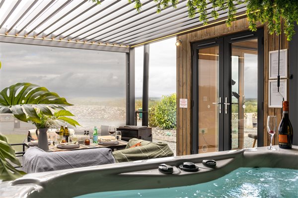 Private hot tub beside a luxury cabin with covered outdoor seating and countryside views at Galloway Retreats, Dumfries and Galloway. Private hot tub beside a luxury cabin with covered outdoor seating and countryside views at Galloway Retreats, Dumfries and Galloway.