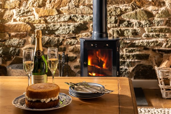 Champagne by the fire in luxury holiday cottage at Tredarrup Farm, Cornwall