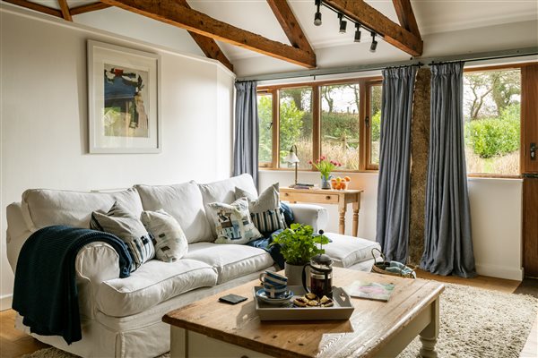 Sofa in living area of luxury farm holiday cottage, Cornwall