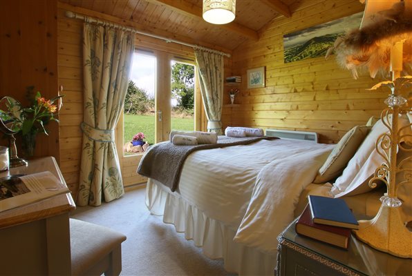 Kingsize bed with double doors leading to garden at foot of bed