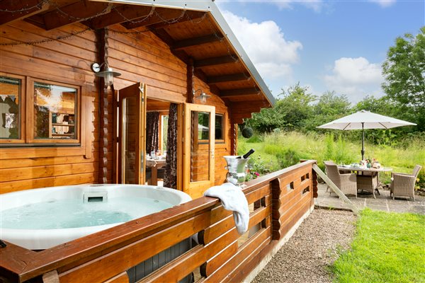 log cabin with hot tub on veranda