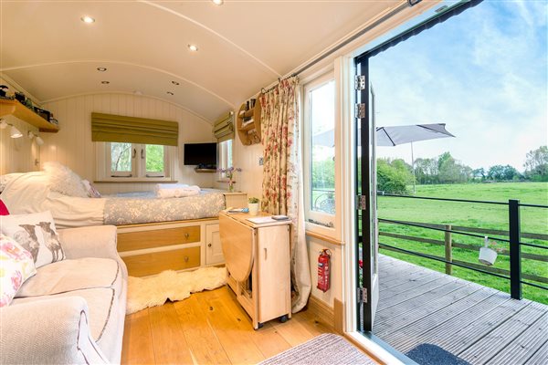 left side inside hut and right side view across green field 