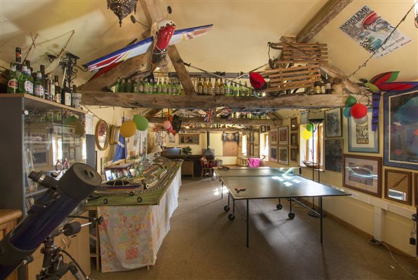 Characterful heated games room with large log burner, pinball, bar billiards, darts and smart TV
