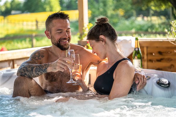 couple enjoying a drink in the hot tub 