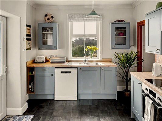 Kitchen has dishwasher, microwave, tall upright fridge, electric cooker and hob