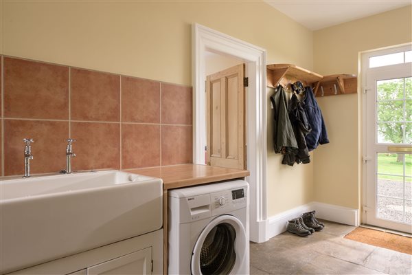 Back entrance hallway with coat storage and laundry