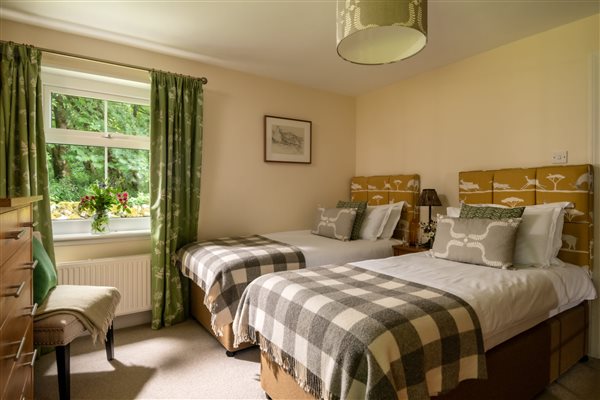 Ground floor twin bedroom next to the bathroom with garden views