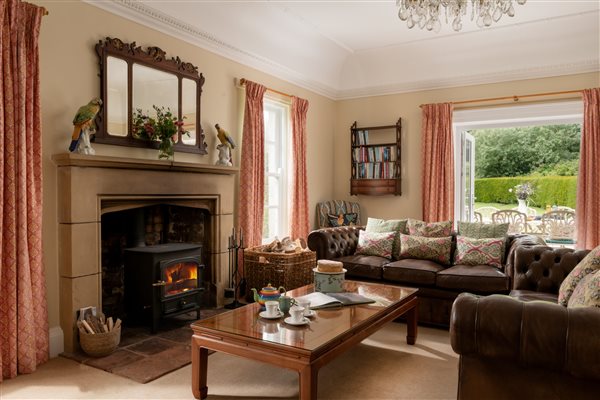 Sitting room with woodburning stove and doors to patio and garden