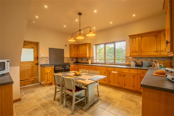 Country kitchen in Ty Gwair 6, all amenities including dishwasher, air fryer and nespresso machine. Luxury barn converted suite at Snowdonia Holidays Tyddyn Du Farm Eryri. Perfect getaway destination in North Wales.