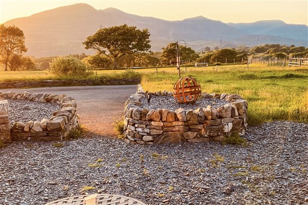 Sunset views over the Eryri Mountains from your own private patio area outside Ty Gwair 5 - a luxury barn converted suite centrally located in Eryri (Snowdonia) National Park. Escape and recharge at Tyddyn Du farm.