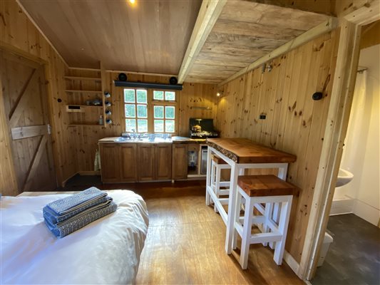 Hut interior, showing handmade dining table and stools made from locally sourced timber