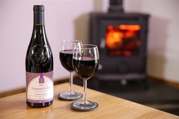 A glass of red wine by the fireside